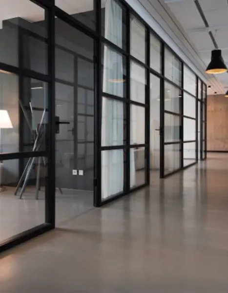 Modern office corridor with glass-walled meeting rooms
